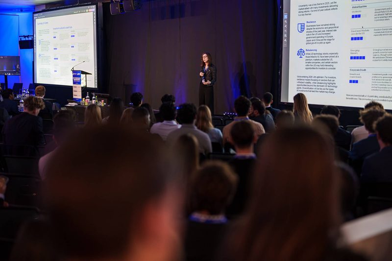 A speaker presenting market slides to a full room